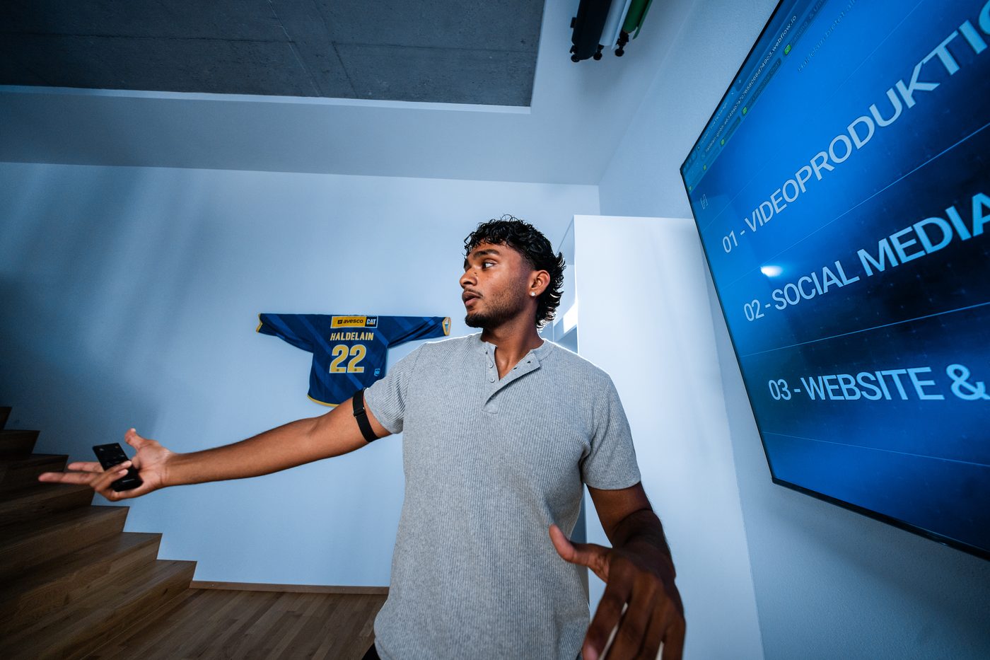 Rojith Ragavan präsentiert mit offenen Armen vor einem Screen im Haldelain-Loft