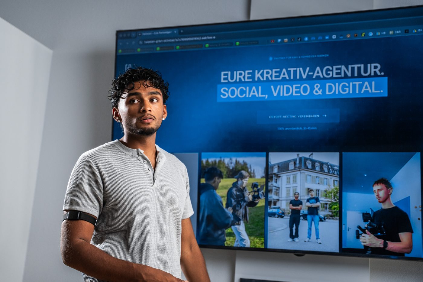 Rojith Ragavan vor dem Screen «Eure Kreativ-Agentur für Social, Video &amp; Digital»